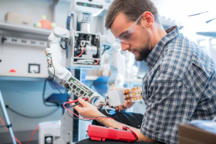 Male worker in plaid shirt and safety goggles performs robot-assisted labor.|Graph showing how inflation has impacted Tennessee companies|Graph showing what respondents think are the chances the U.S. will fall into a recession this year|Figure showing what respondents believe best characterize work arrangements at their companies