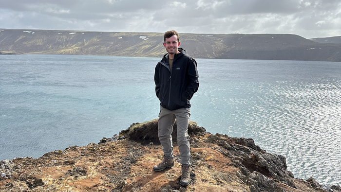 Kaelan Cook stands on a cliffside over a body of water in Iceland.|Kaelan Cook stands on a cliffside over a body of water in Iceland.|Kaelan Cook stands on a cliffside over a body of water in Iceland.