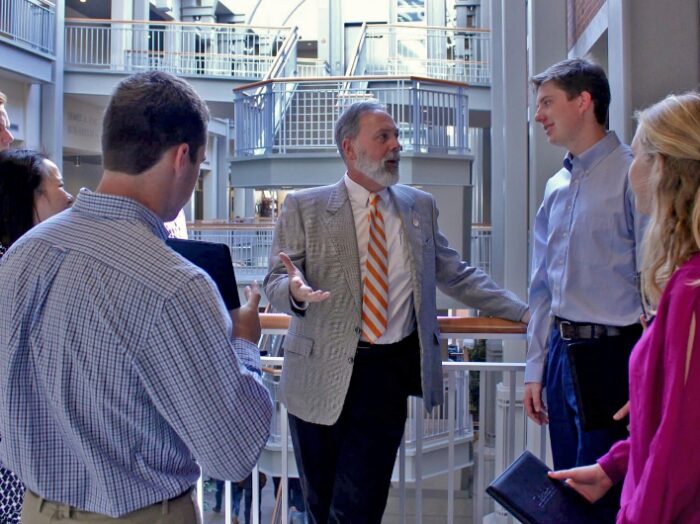 students talking with professor in atrium