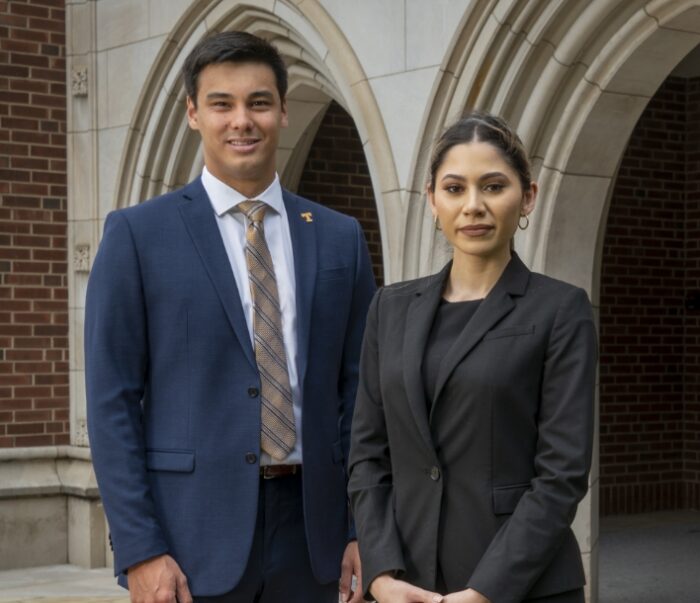 professional man and woman standing outside of Haslam Business Building