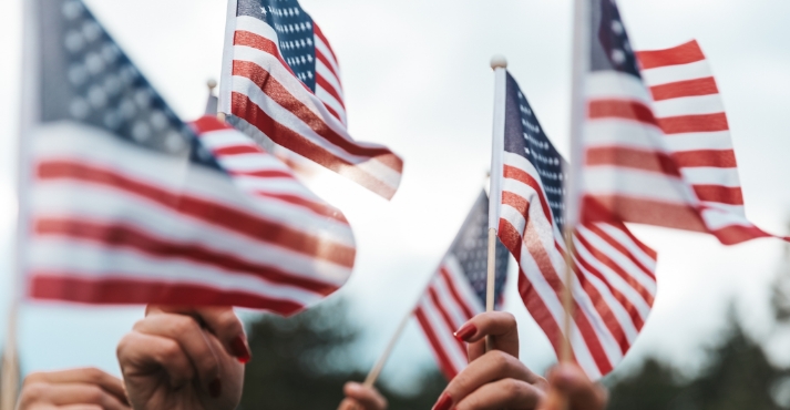 People waving US flags at an event